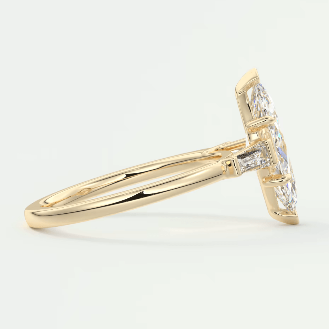 18k yellow gold diamond engagement ring with a marquise-cut center stone and baguette side stones.