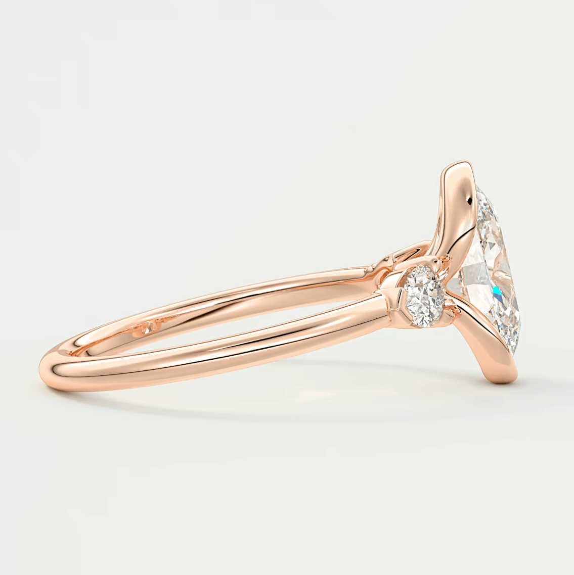 18k rose gold diamond engagement ring with a marquise-cut center stone and small round accent stones.