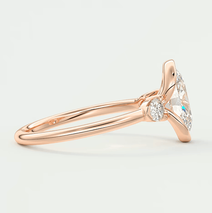 18k rose gold diamond engagement ring with a marquise-cut center stone and small round accent stones.
