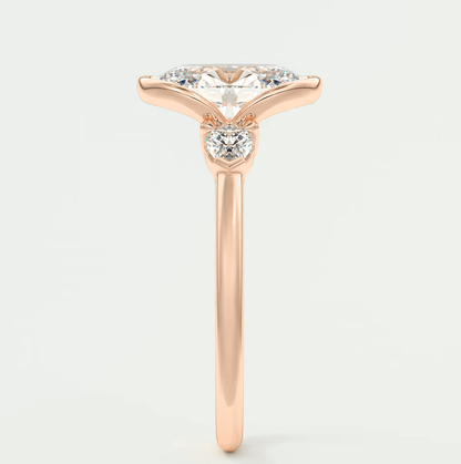 18k rose gold engagement ring with marquise-cut diamond and small round diamonds on band.