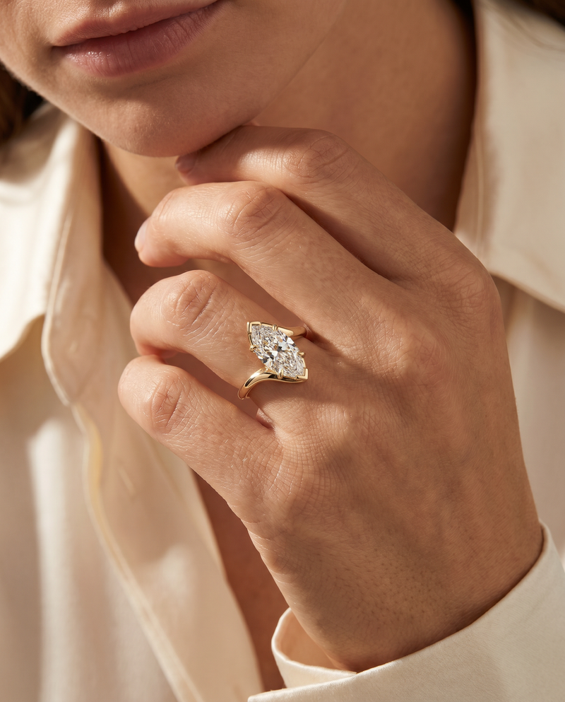 Close-up of a hand wearing a diamond ring with a soft focus background