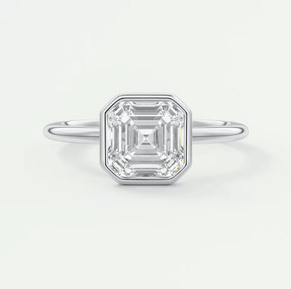 18k white gold emerald cut diamond engagement ring with a bezel setting.