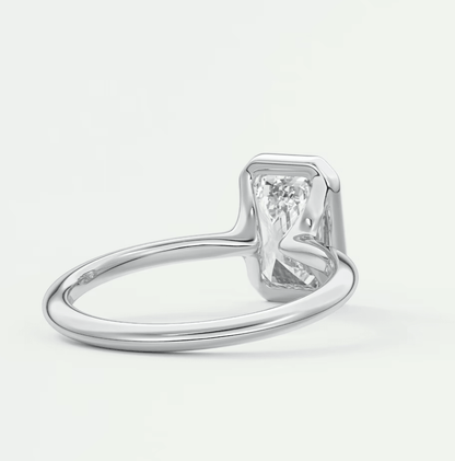 White gold emerald cut diamond engagement ring with a solitaire setting.