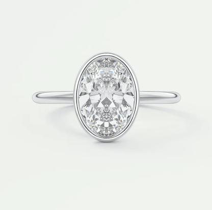 18k white gold oval diamond engagement ring with a bezel setting.