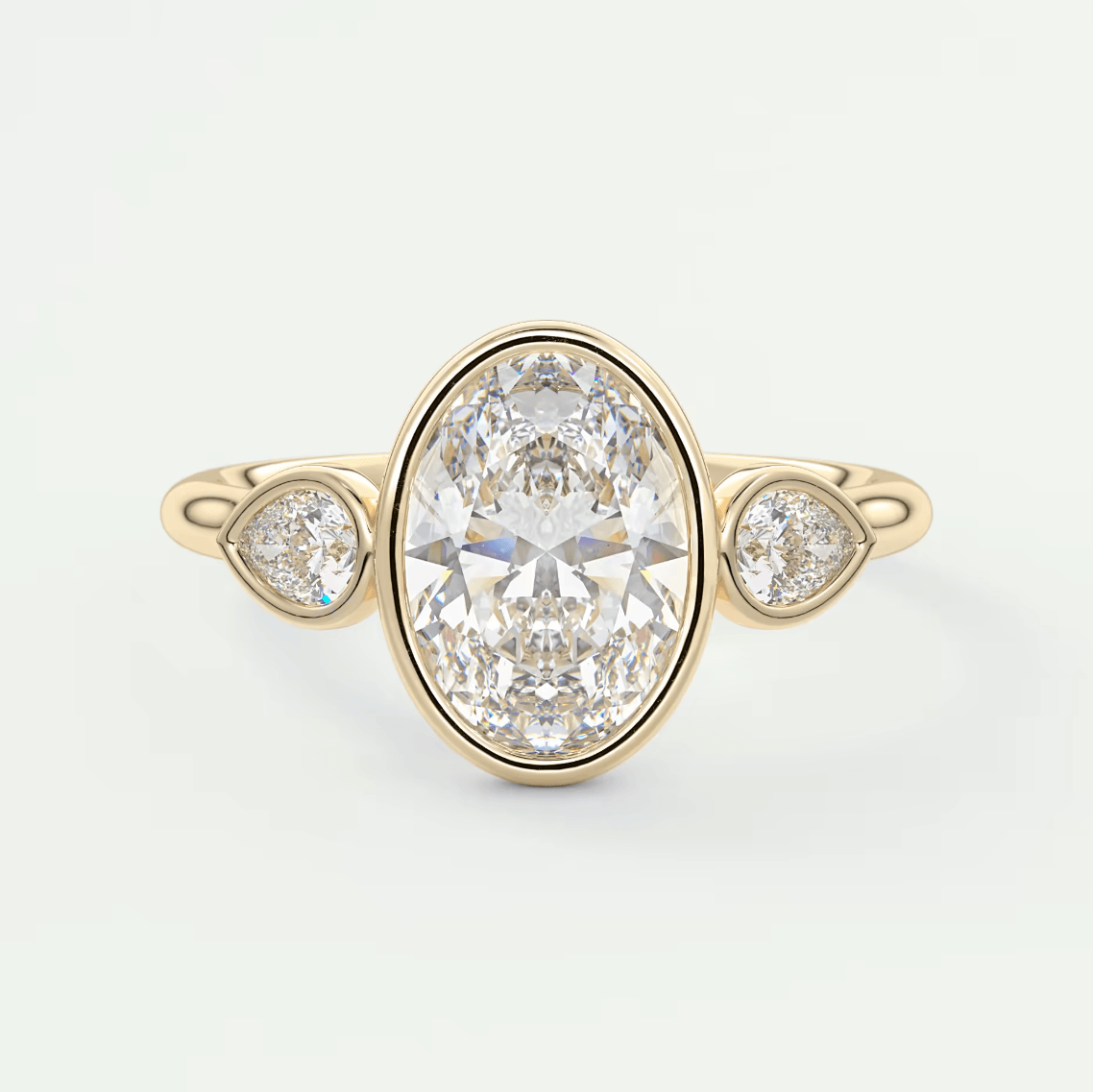 18k yellow gold diamond engagement ring with an oval-cut center stone and two smaller round diamonds.