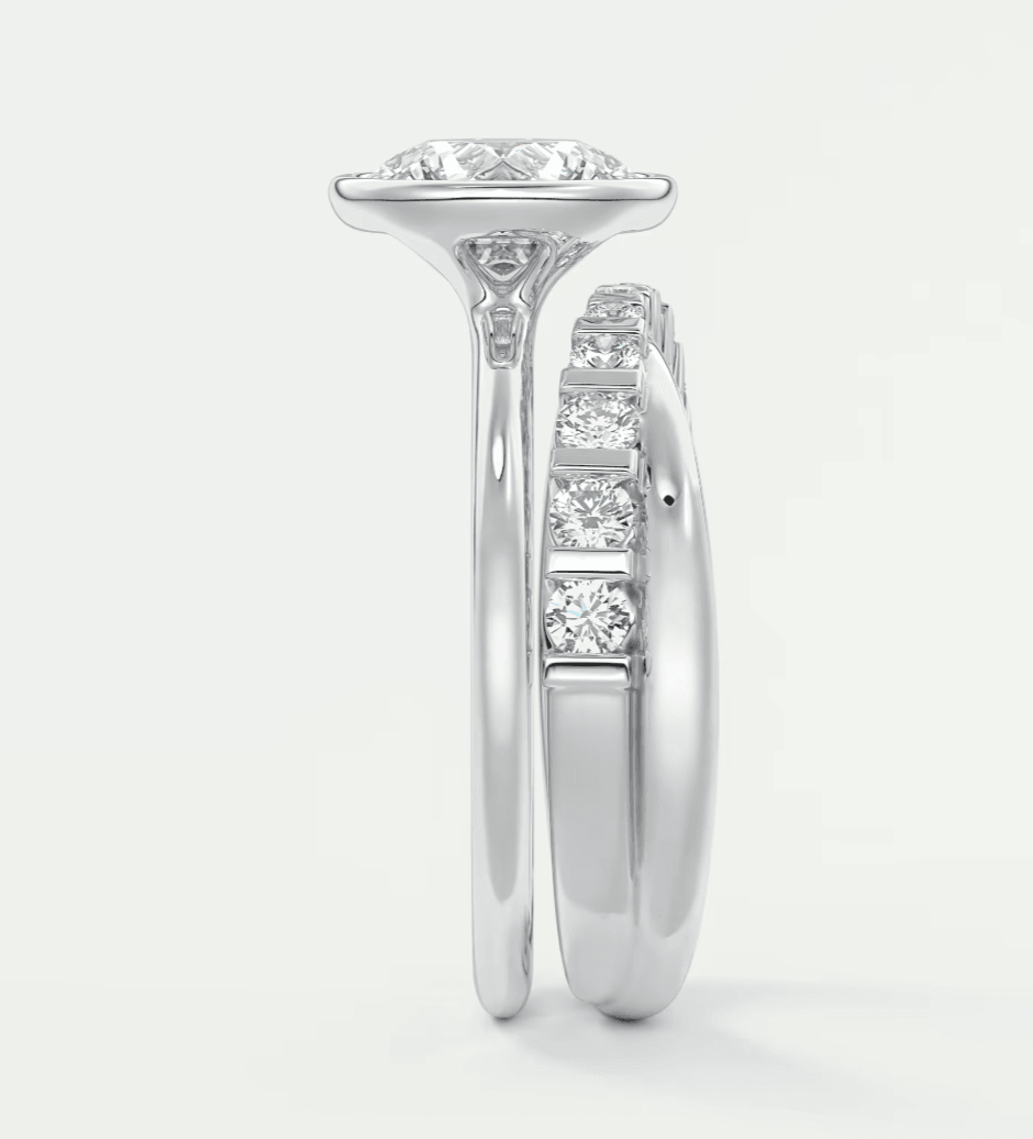 18-karat white gold diamond engagement ring with a cushion-cut center stone and four smaller diamonds on the band.