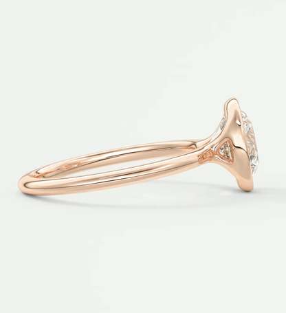 18-karat rose gold engagement ring with a round diamond center and small diamonds on the band.