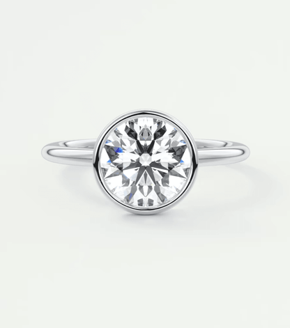 18-karat white gold diamond engagement ring with a bezel setting.
