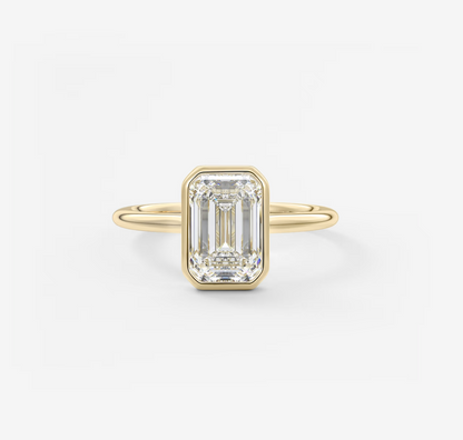 Gold ring with a rectangular diamond on a white background