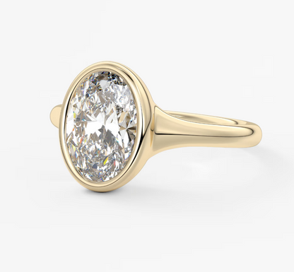 18-karat yellow gold diamond engagement ring with a bezel setting.