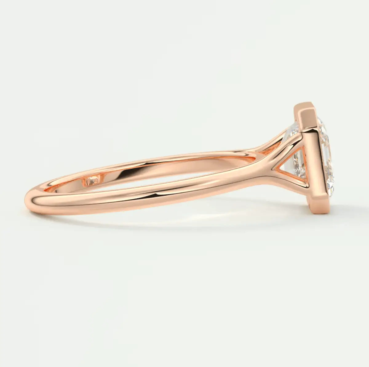18k rose gold engagement ring with a round diamond center stone and smaller diamonds set in the band.