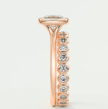 18-karat rose gold diamond engagement ring with a marquise-cut center stone and round side stones.