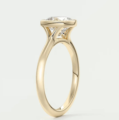 18-karat gold engagement ring with a cushion-cut diamond.
