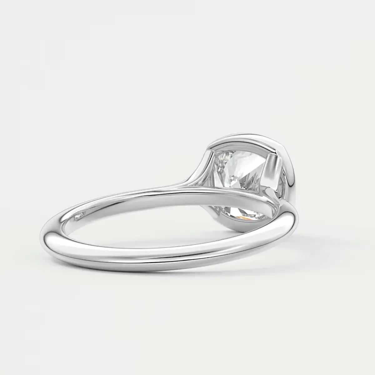 Silver solitaire diamond engagement ring with a cushion-cut gemstone.