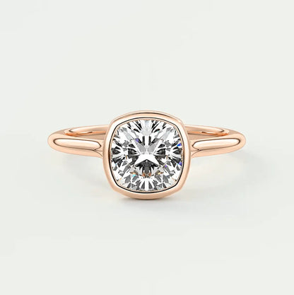 Rose gold cushion-cut diamond engagement ring with a bezel setting.