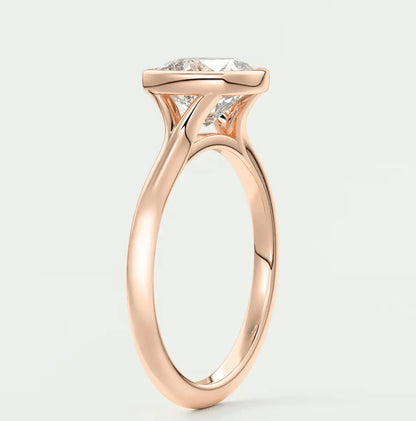 Rose gold engagement ring with a large, cushion-cut diamond and delicate band design.