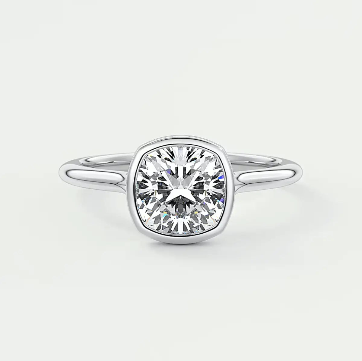 Cushion-cut diamond engagement ring with white gold band, featuring a bezel setting.