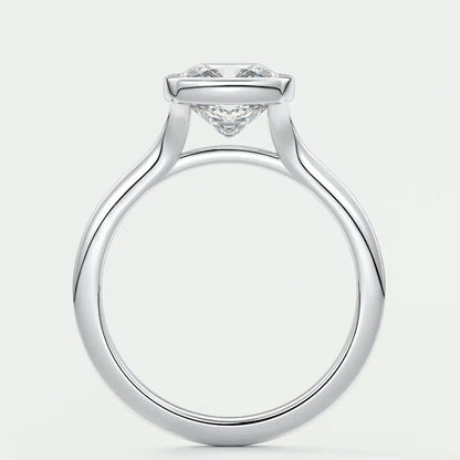 18-karat white gold engagement ring with a round diamond center stone and delicate band design.