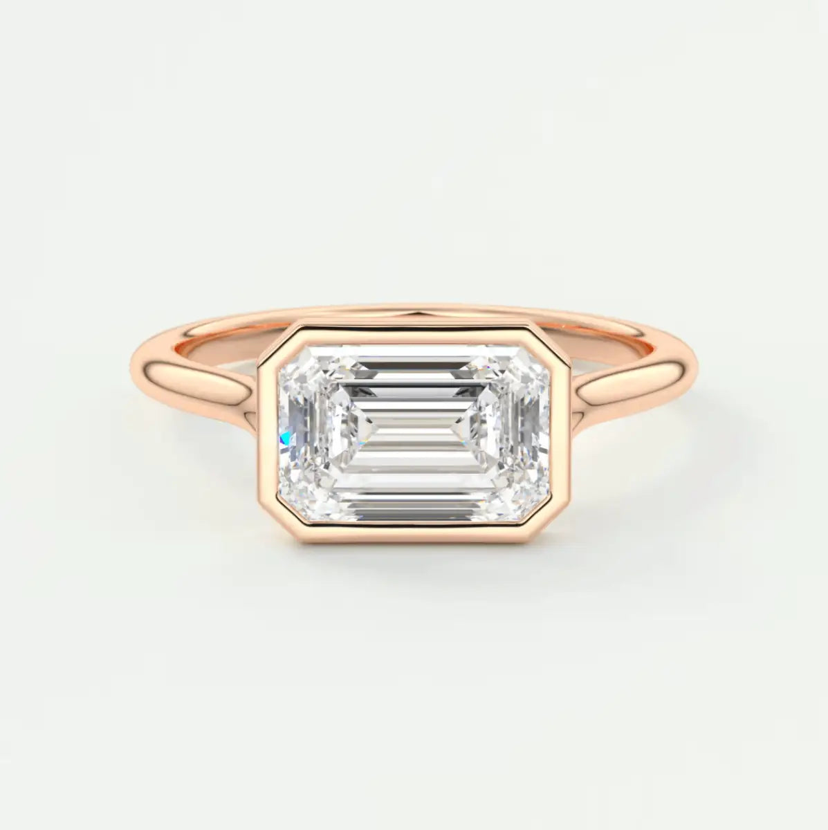 18-karat rose gold emerald-cut diamond engagement ring.