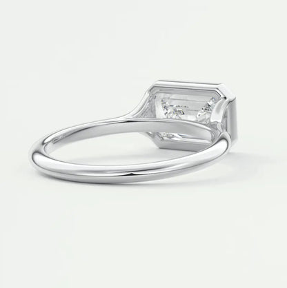 Silver diamond engagement ring with a rectangular cut gemstone and small side stones.