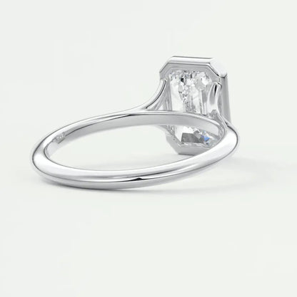 18-karat white gold engagement ring with a baguette-cut diamond.