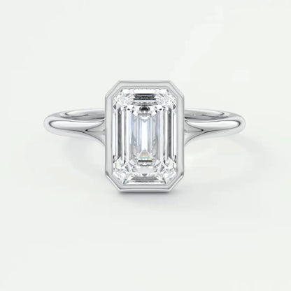 18k white gold emerald cut diamond engagement ring with a bezel setting and milgrain detailing.
