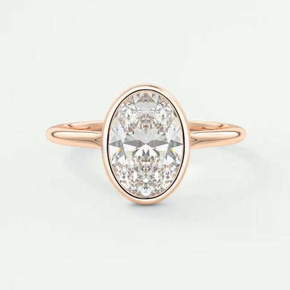 Rose gold oval diamond engagement ring with a bezel setting.