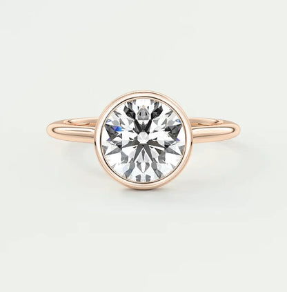Rose gold diamond engagement ring with a bezel setting and elegant band design.