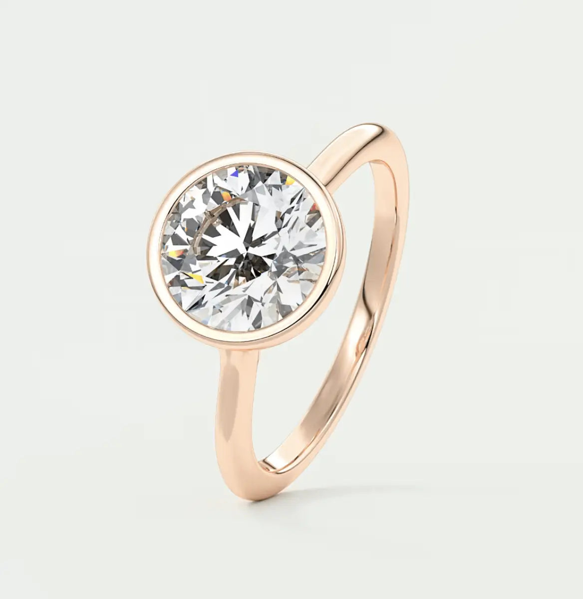 Rose gold diamond engagement ring with a bezel setting.