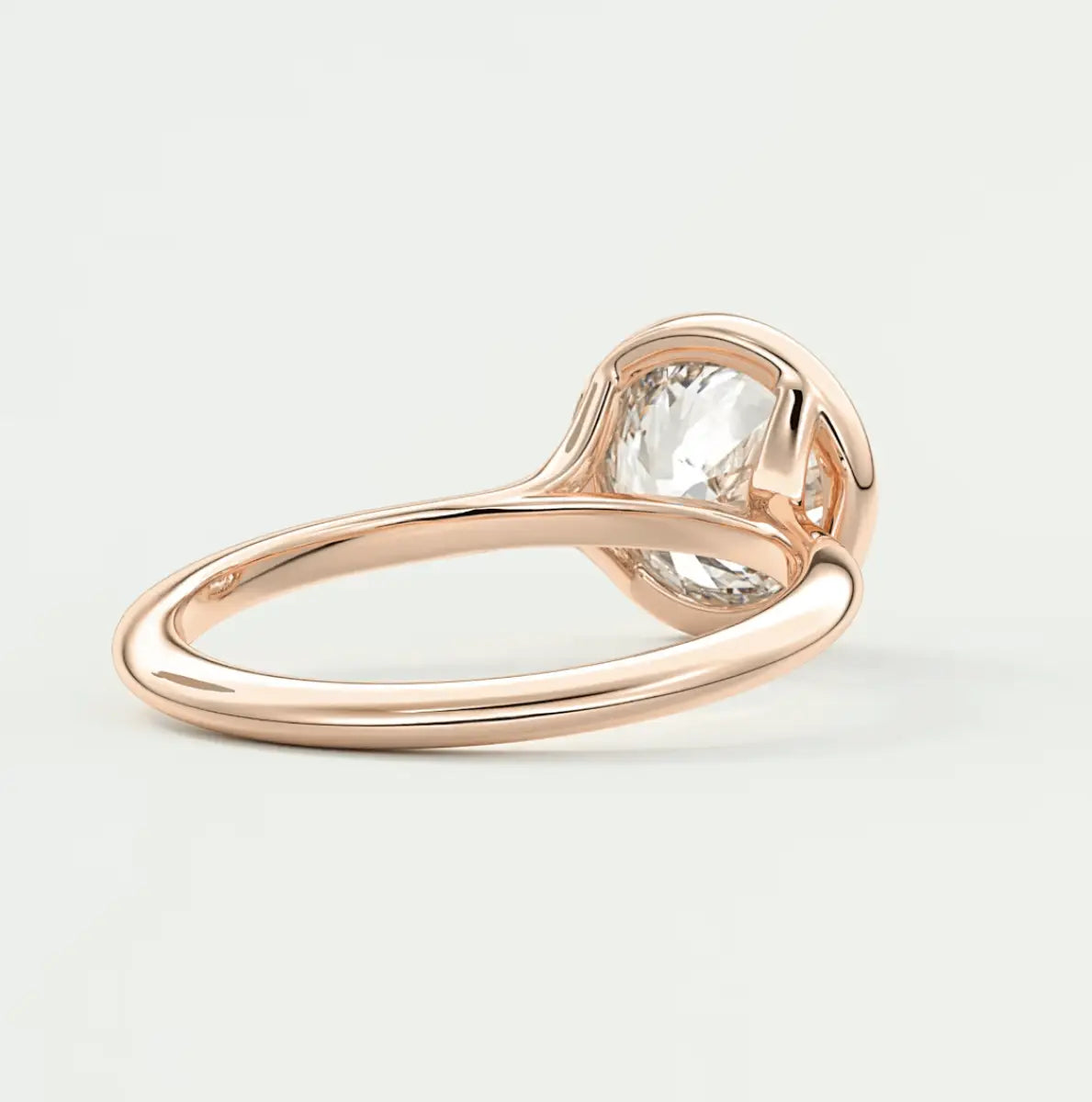 Rose gold engagement ring with a large, pear-shaped diamond.