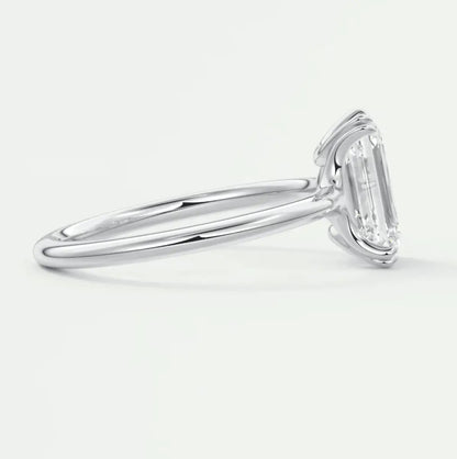 18-karat white gold emerald-cut diamond engagement ring.