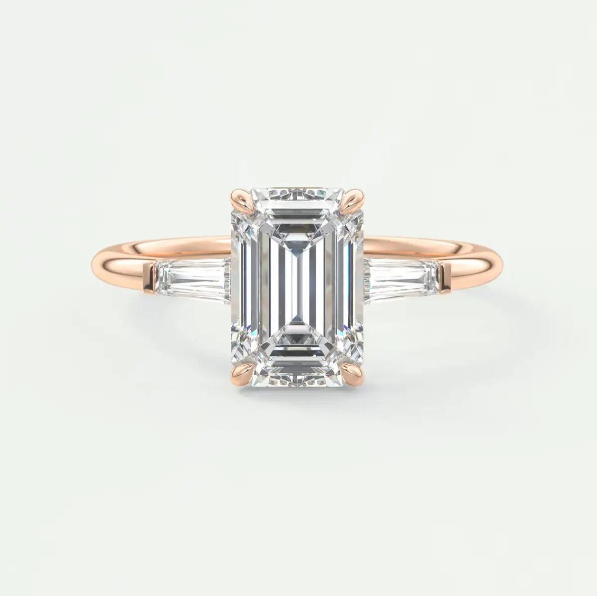 Custom made elysian emerald three-stone engagement ring with tapered baguettes