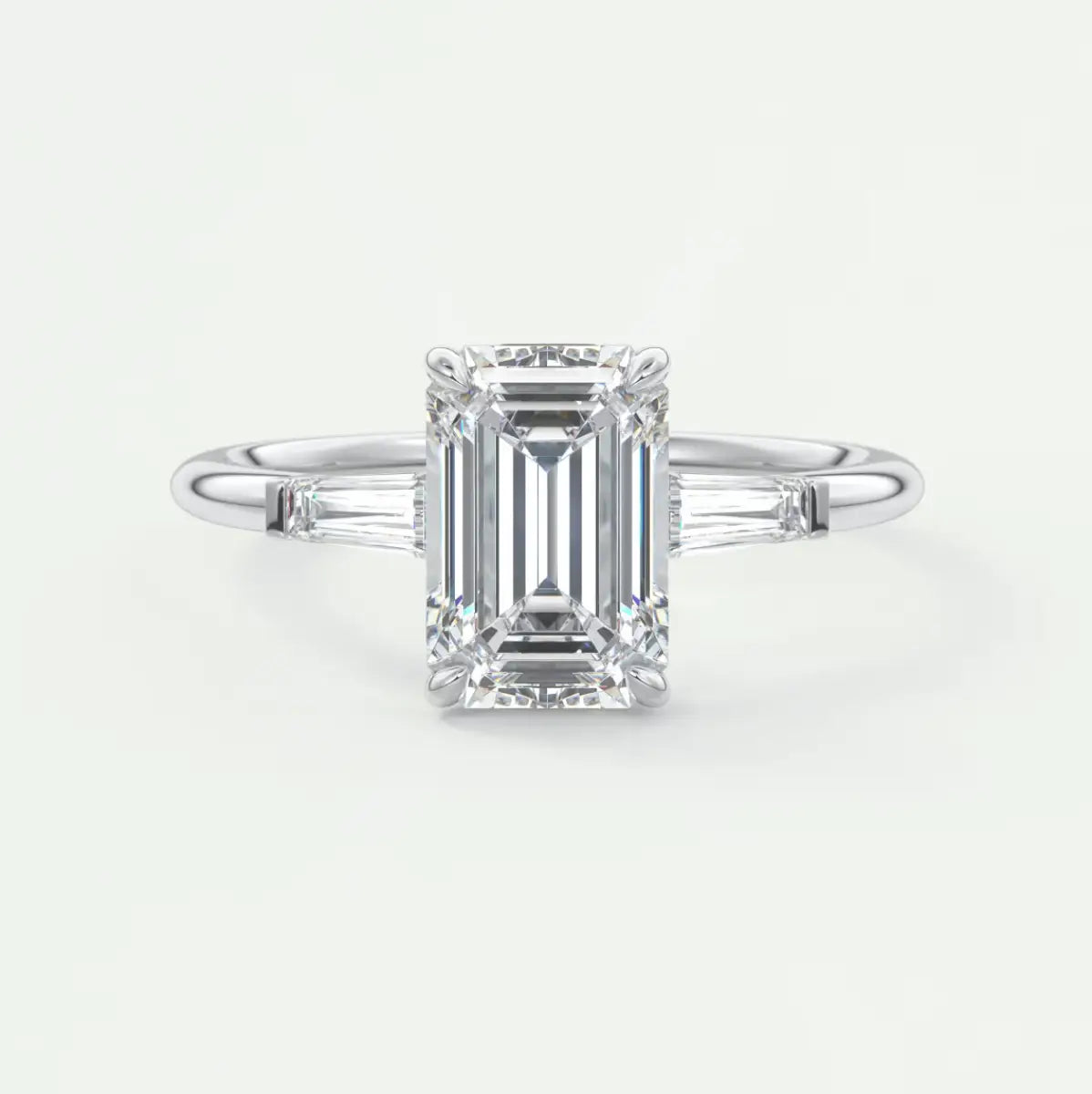 Custom made elysian emerald three-stone engagement ring with tapered baguettes