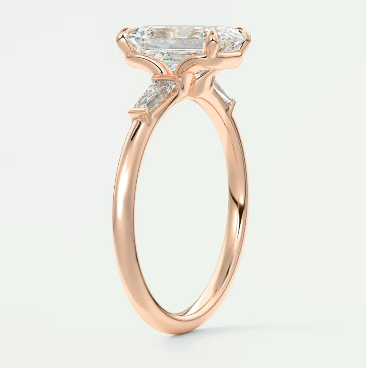 Custom made elysian emerald three-stone engagement ring with tapered baguettes