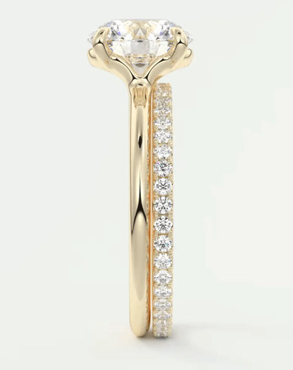 18k yellow gold engagement ring with a round diamond center stone and pavé set diamonds on the band.