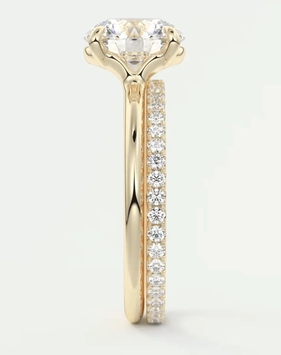 18k yellow gold engagement ring with a round diamond center stone and pavé set diamonds on the band.