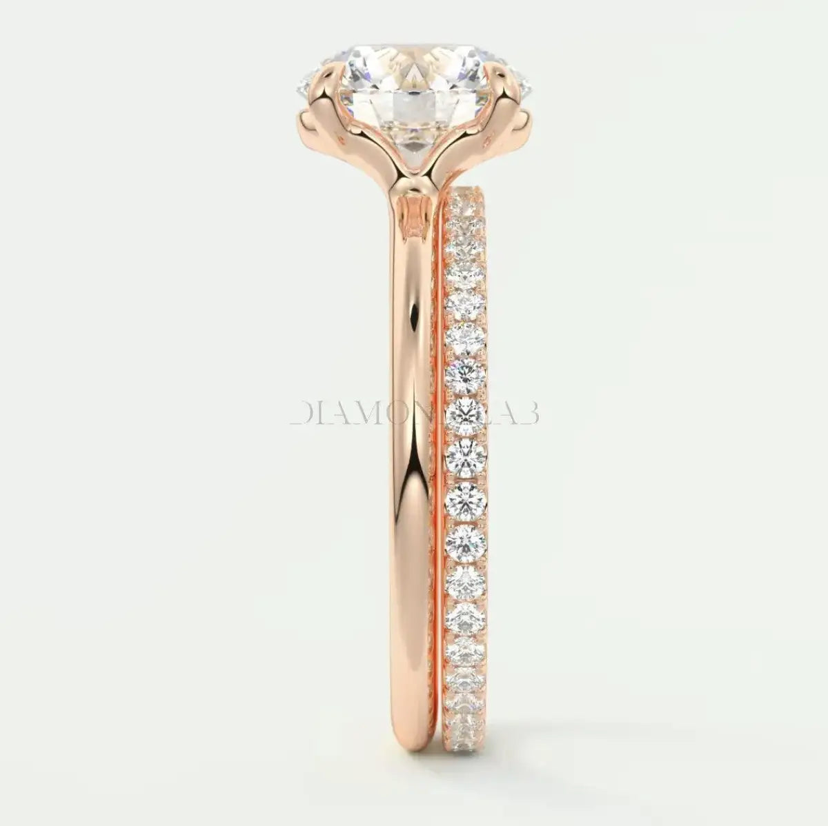 18k rose gold engagement ring with a round diamond center and pavé set diamonds on the band.