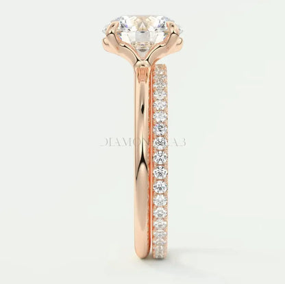 18k rose gold engagement ring with a round diamond center and pavé set diamonds on the band.