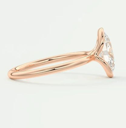 18k rose gold halo engagement ring with a marquise-cut diamond center stone and small diamonds on the band.