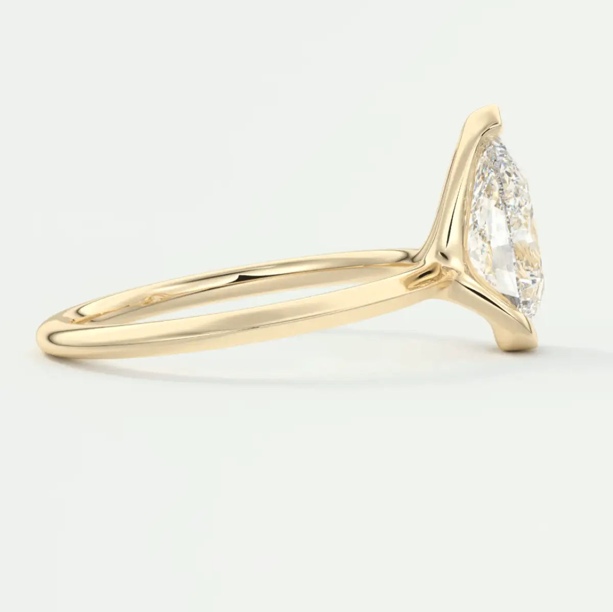 18k gold diamond engagement ring with a pear-shaped center stone and side pavé diamonds.