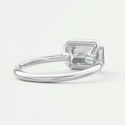 White gold emerald cut diamond engagement ring with a princess-cut center stone.