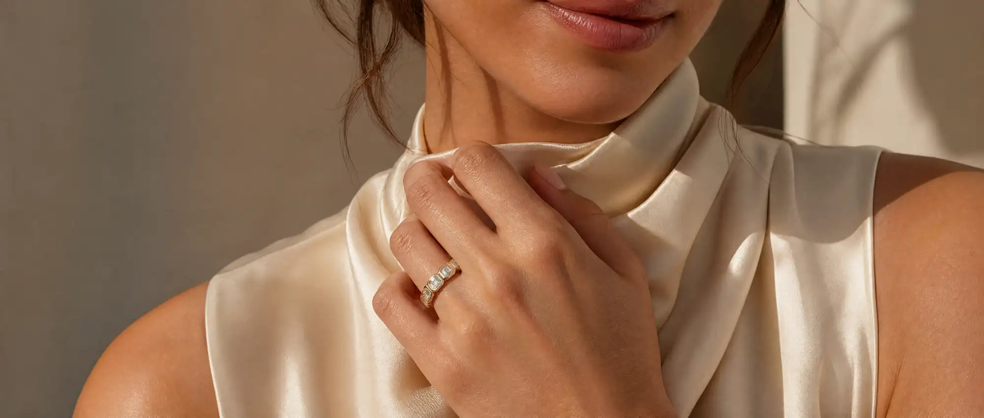 Close-up of a person wearing a beige satin scarf with a neutral background